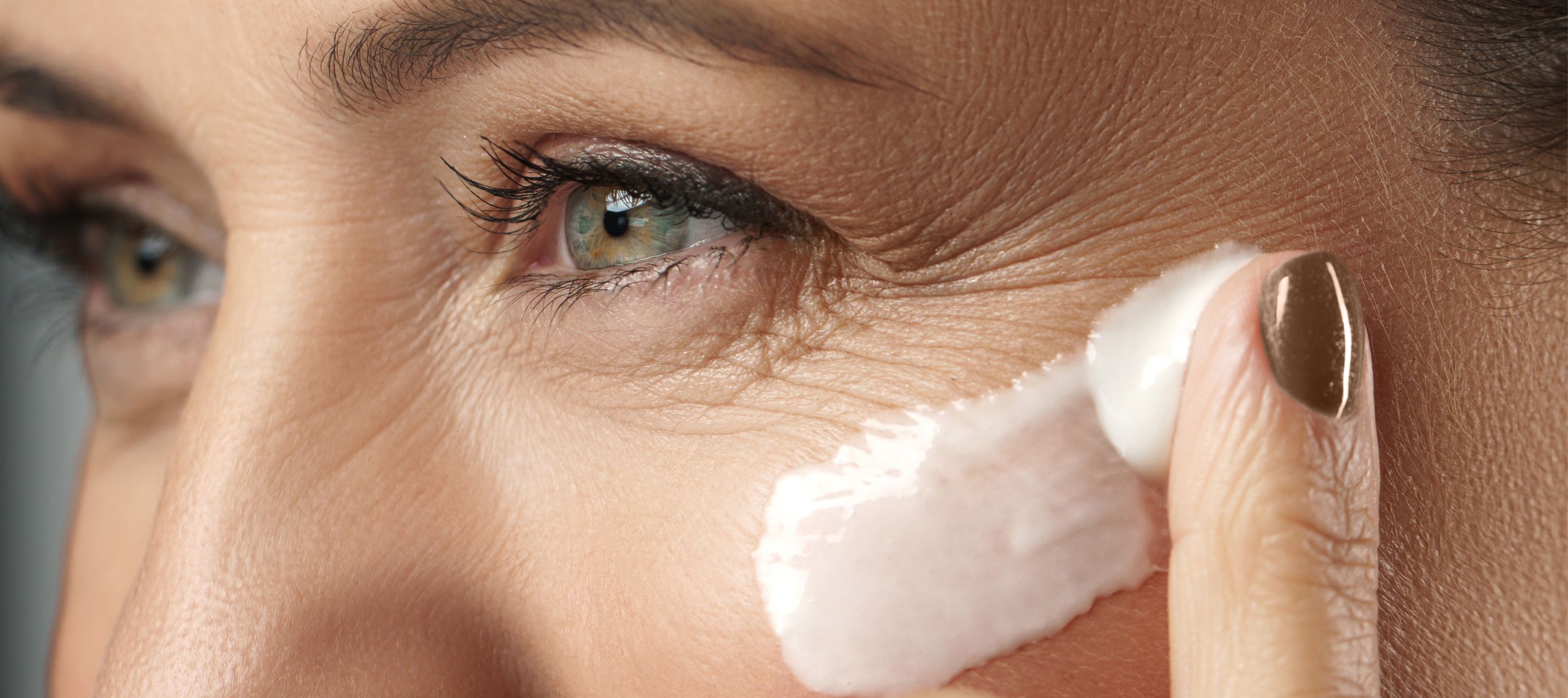 Žena si aplikuje na pleť krém