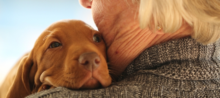Seniorka držící v náručí štěně