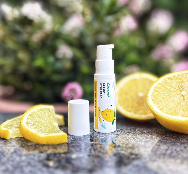 Produkt Citronek mycí olej pro děti stojící vedle citronu.