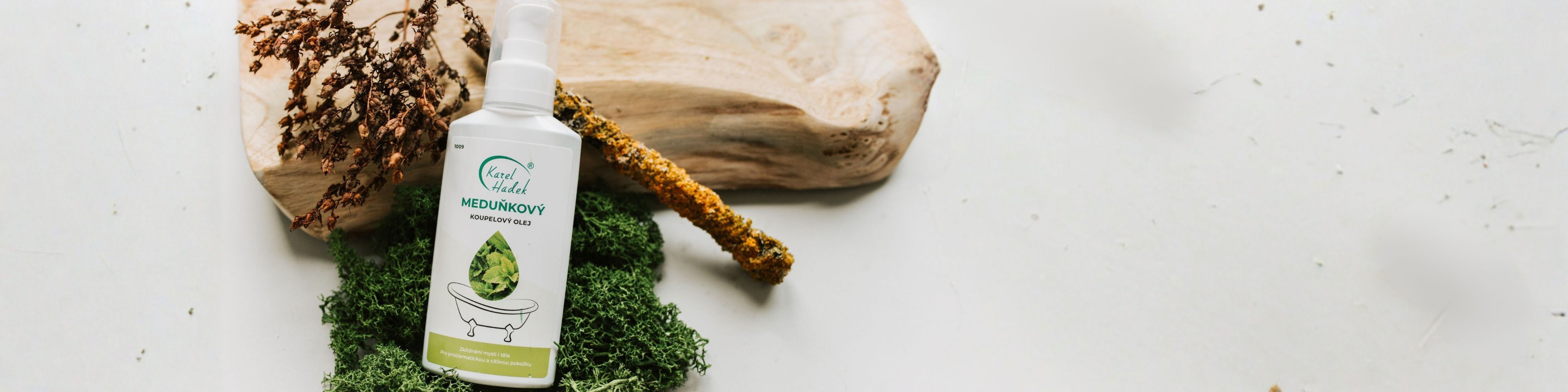 Koupelový olej meduňkový položený na mechu.