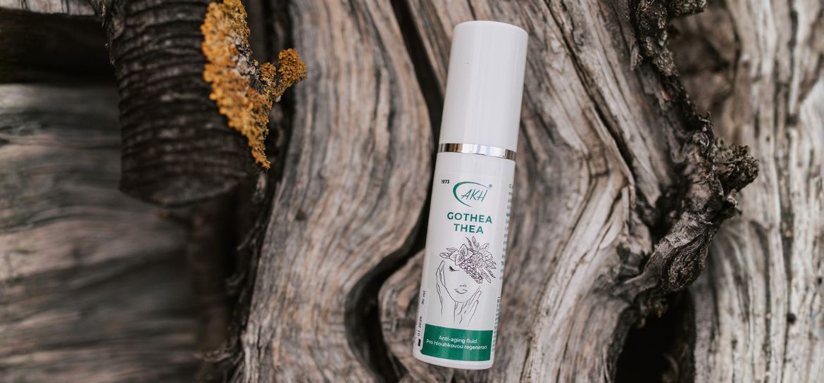 Anti-age fluid GOTHEA THEA ležící na dřevě.