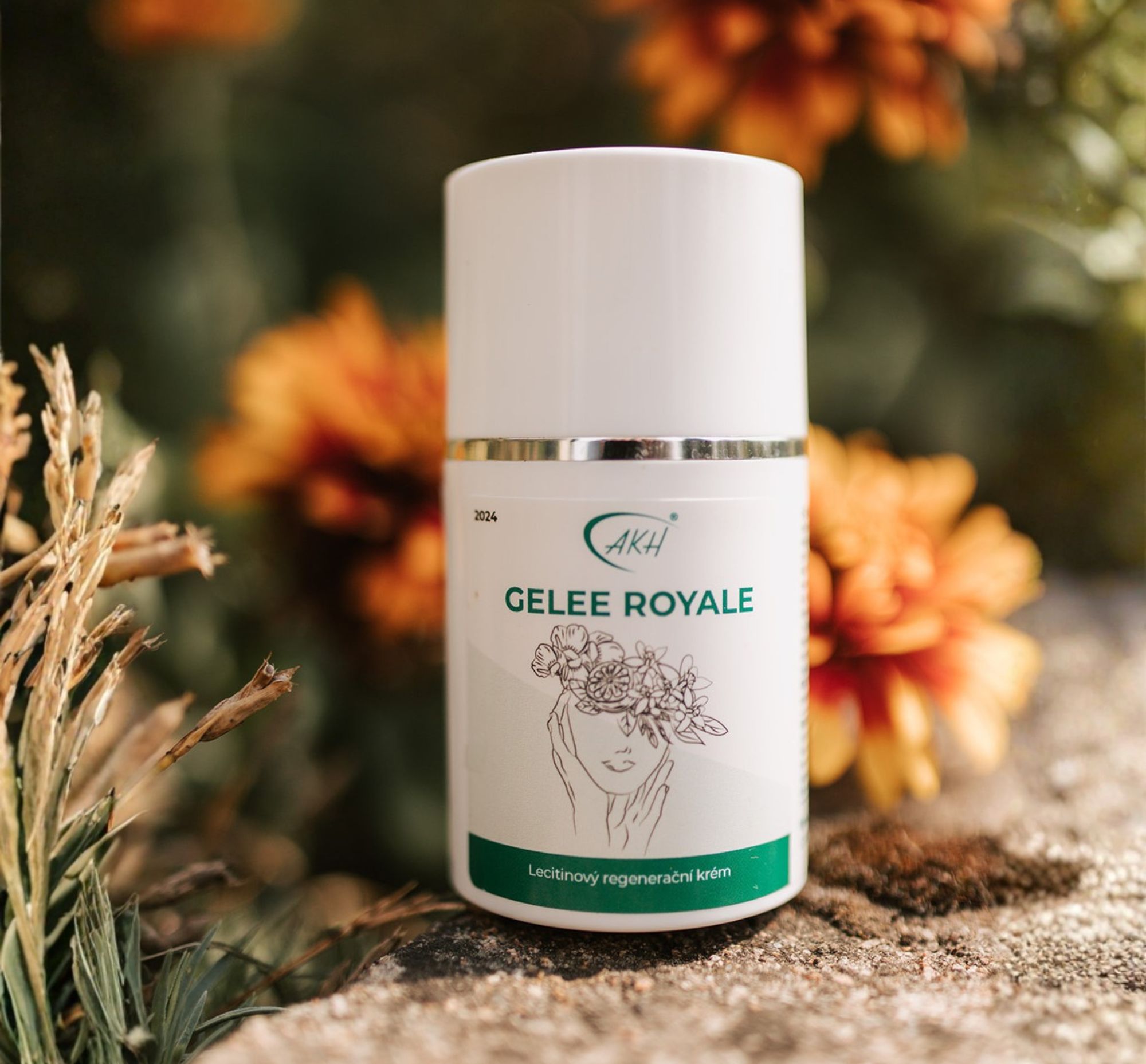 Krém s mateří kašičkou GELEE ROYALE položené v oranžových květinách.